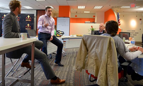 a man in a room with a group of people