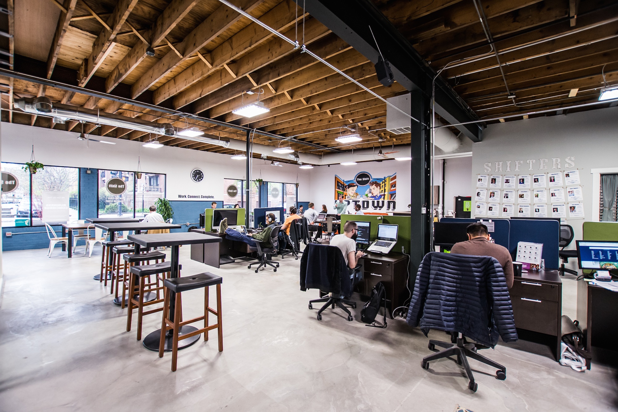 a group of people sitting at desks in an office