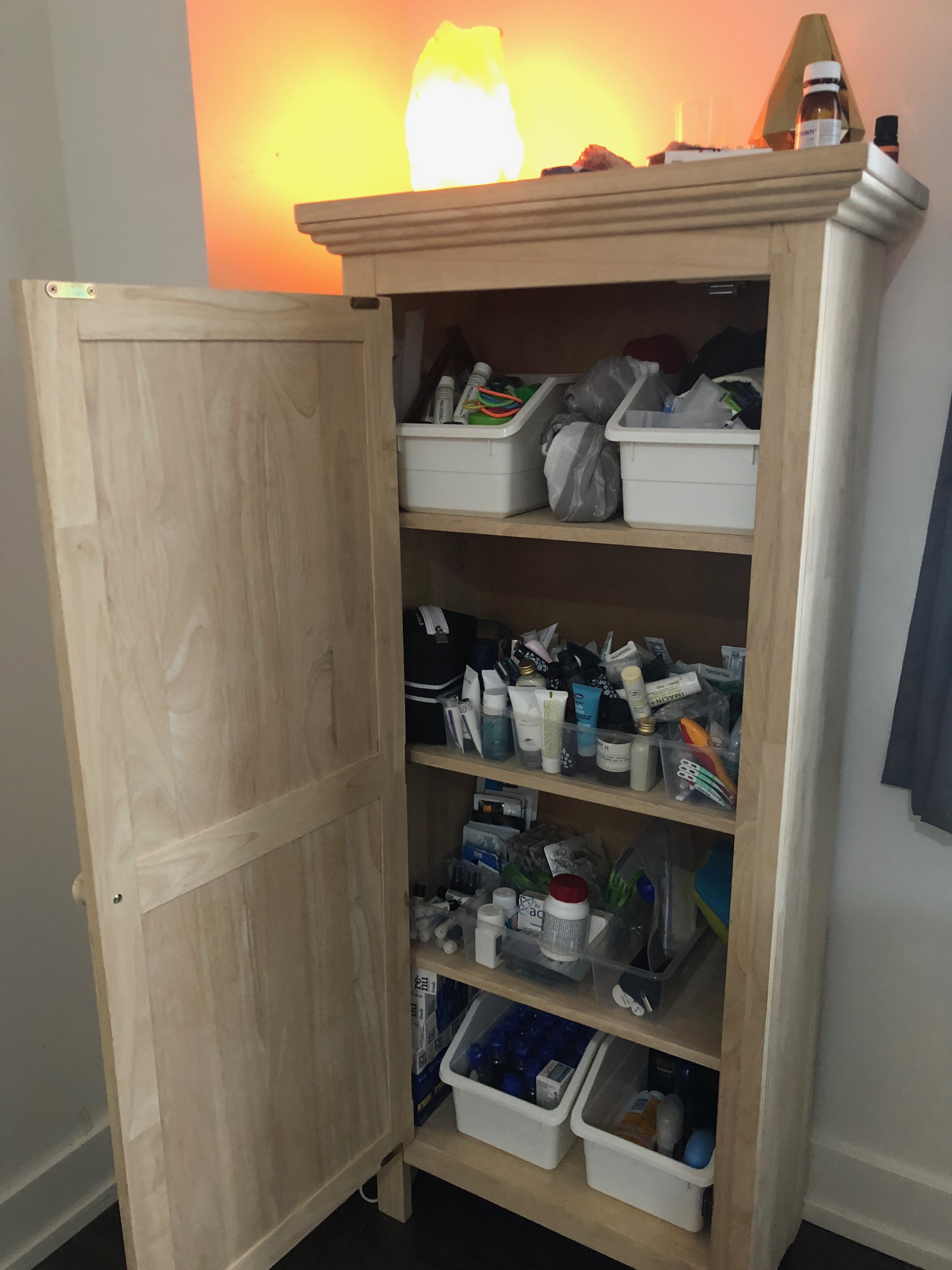 a wooden cabinet with a shelf full of items