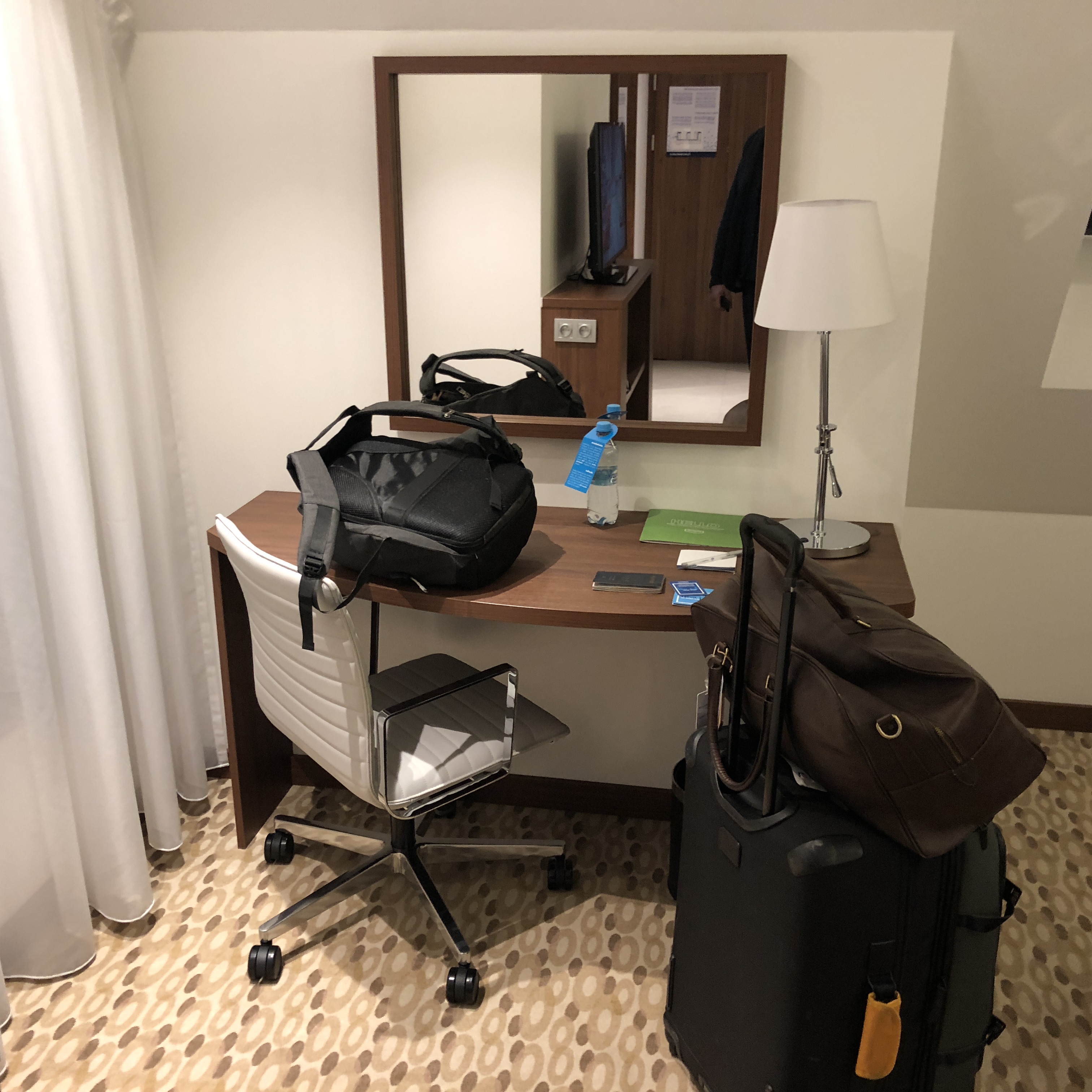 a room with a mirror and luggage