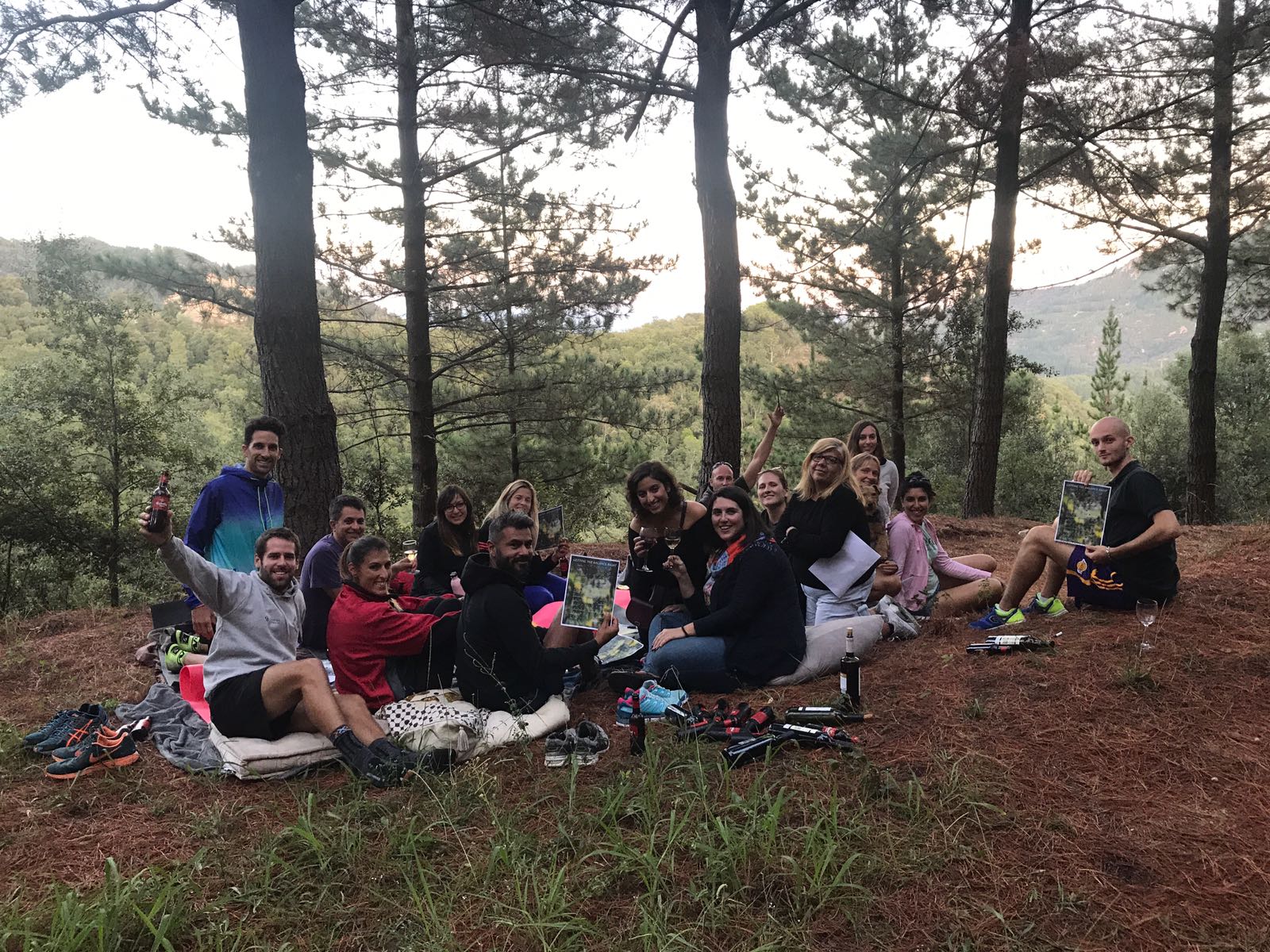 a group of people sitting on the ground in the woods