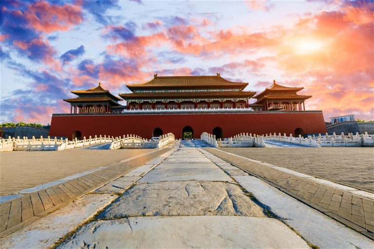 a large building with a red wall and a walkway with Forbidden City in the background