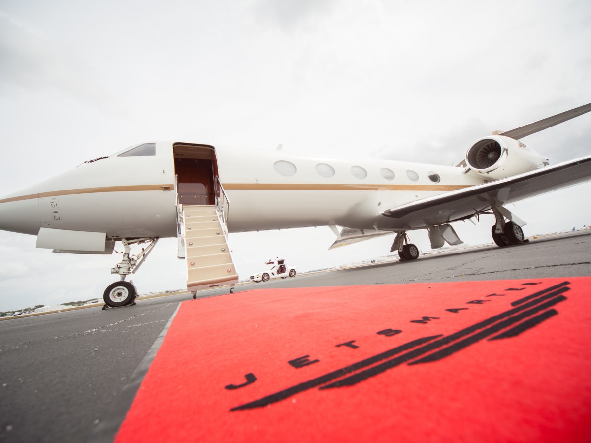 a white airplane with a red carpet
