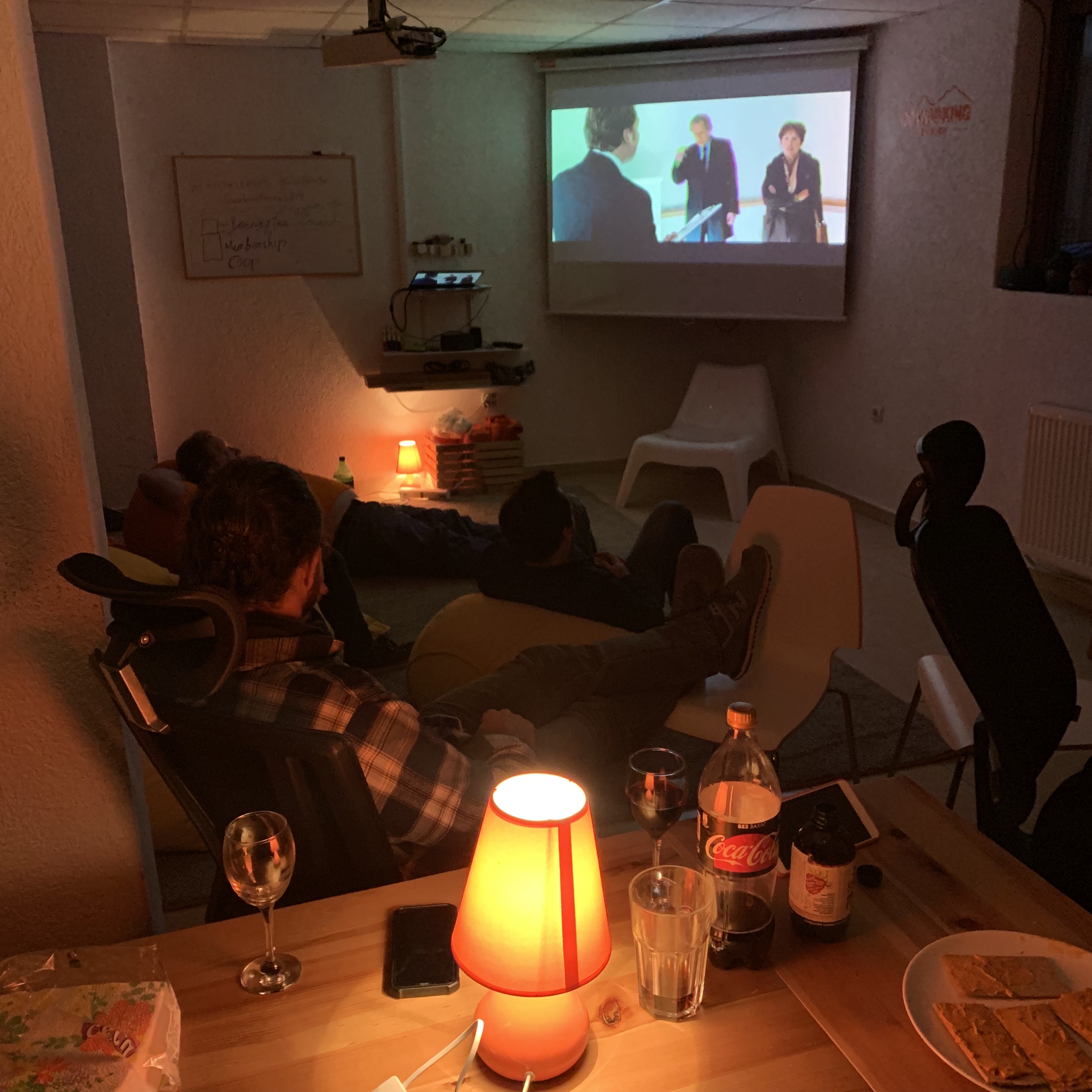 a group of people sitting in chairs watching a projector