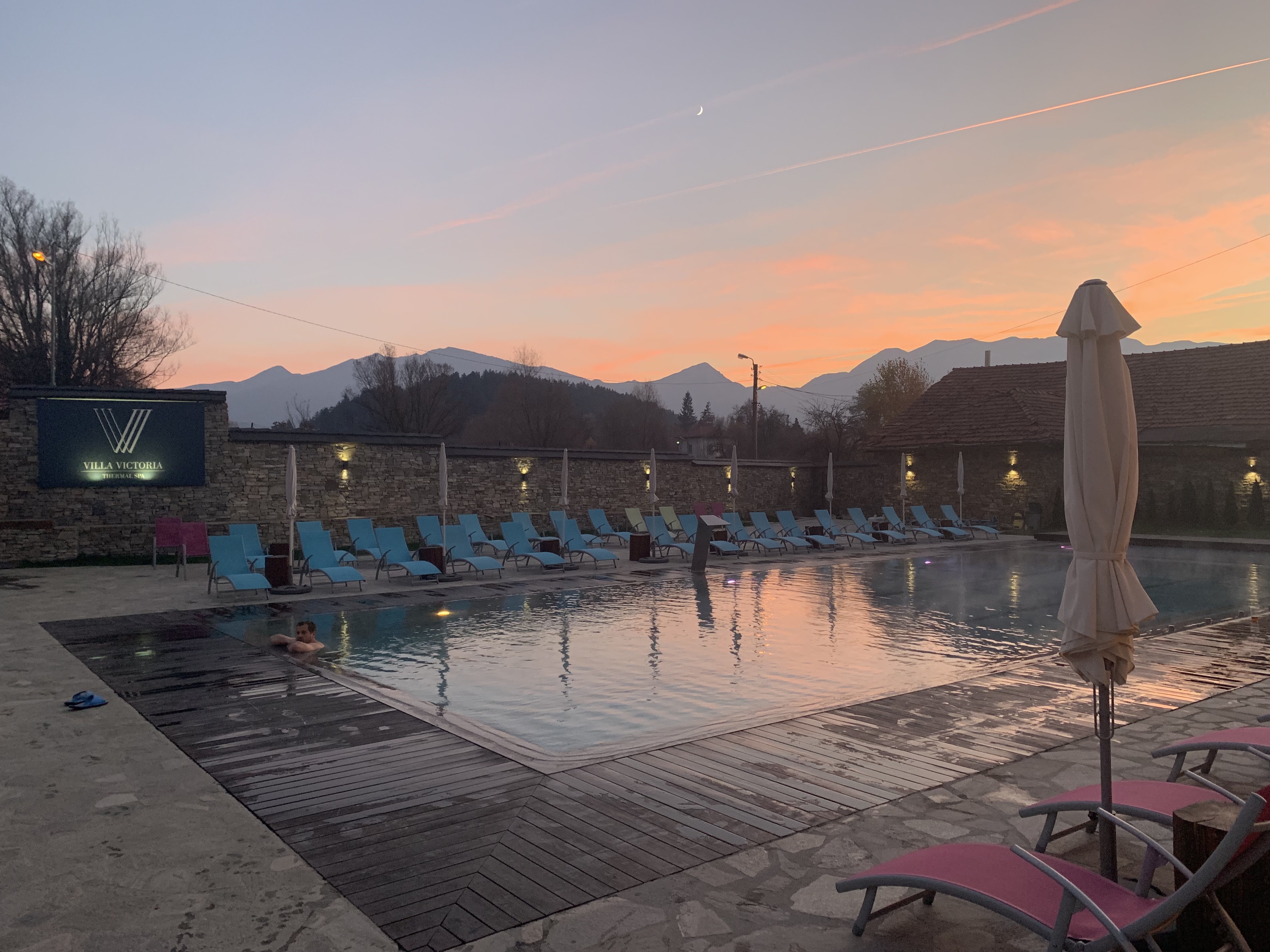 a pool with chairs and umbrellas in the background