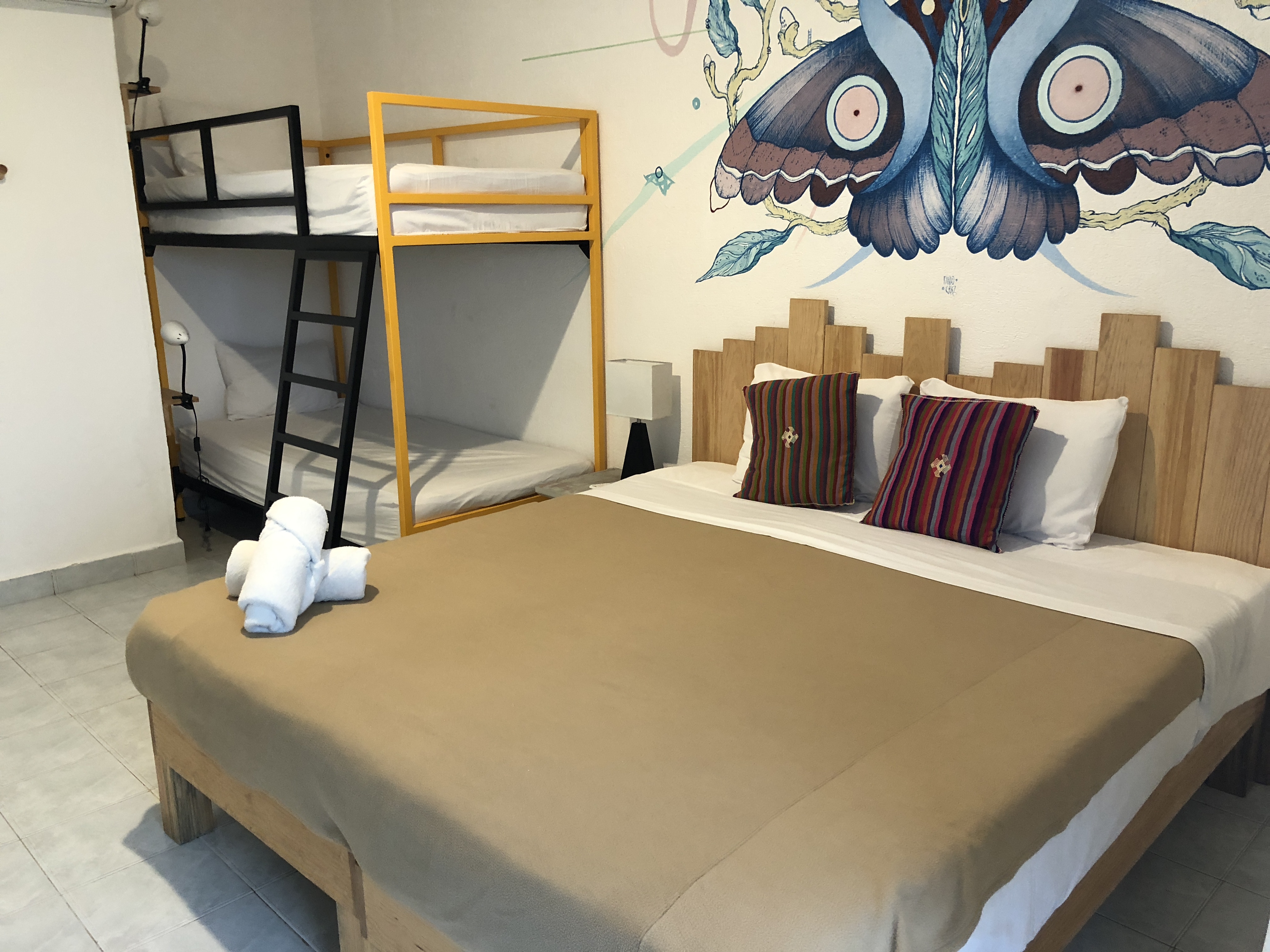 a bed with two bunk beds in a room with a wall mural