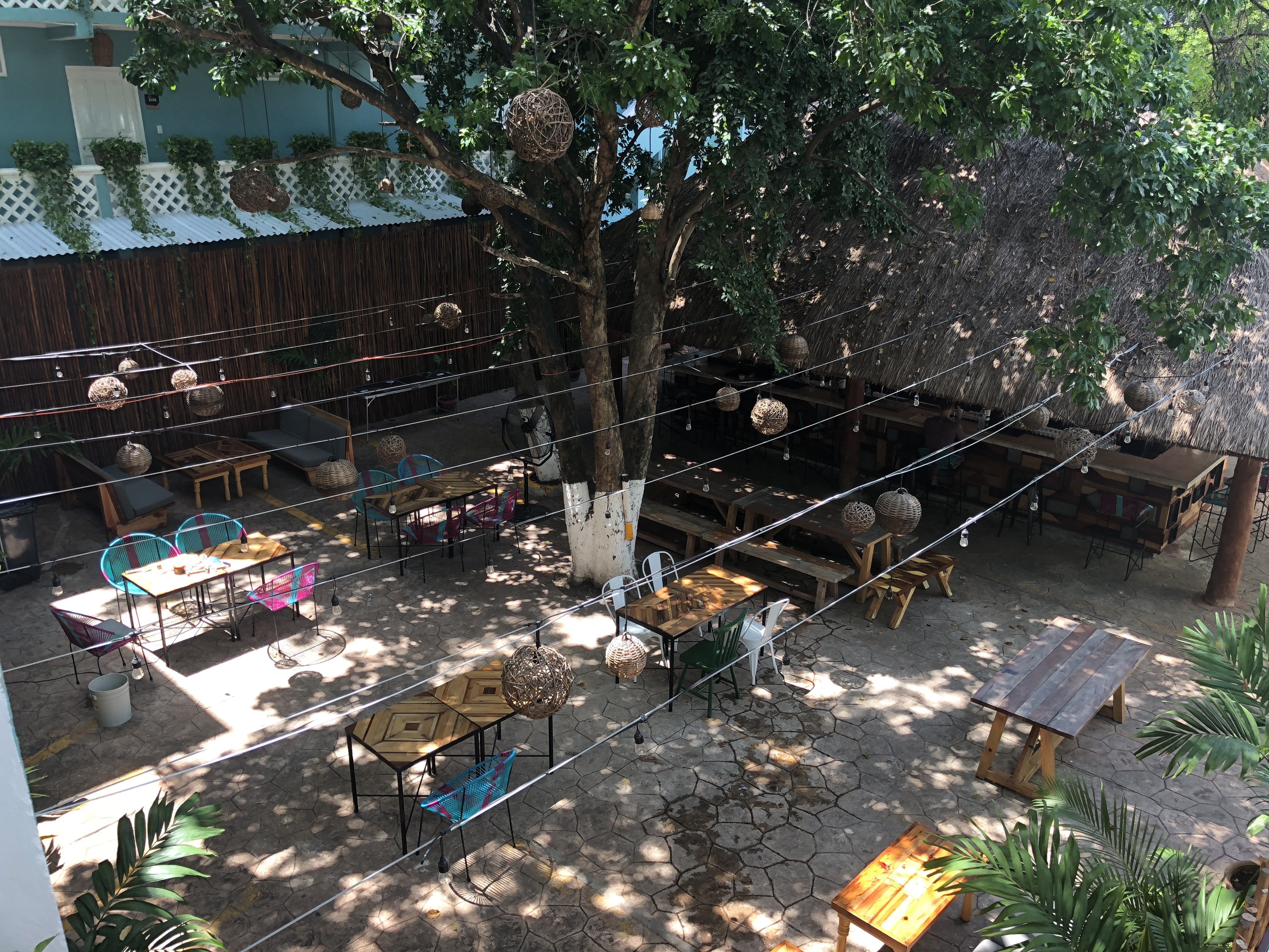 a patio with tables and chairs and a tree