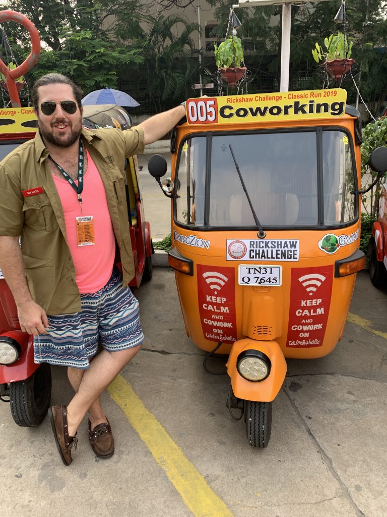 a man leaning on a small orange vehicle