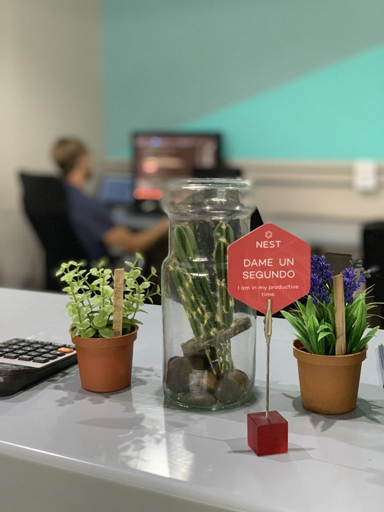 a glass jar with plants in it and a sign on a table
