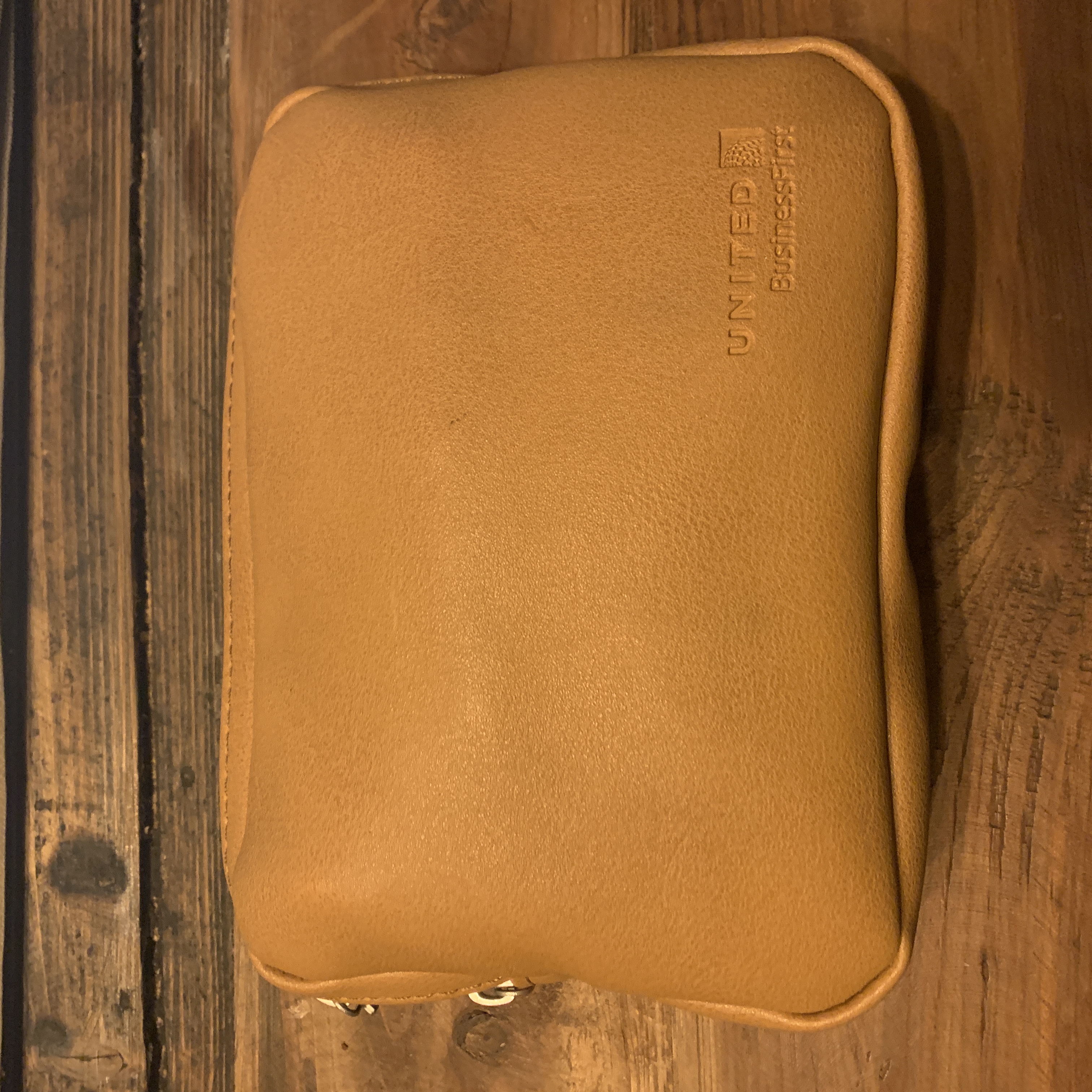a brown leather pouch on a wood surface