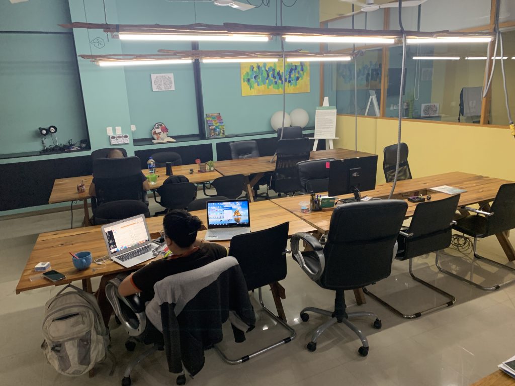 a group of people sitting at a table with laptops