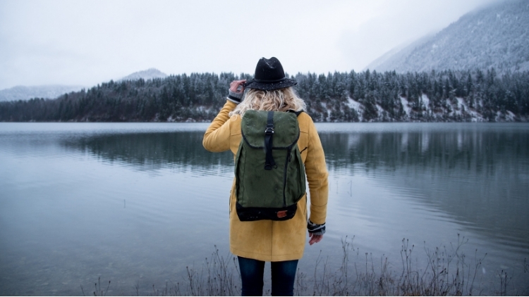 a woman standing in front of a lake