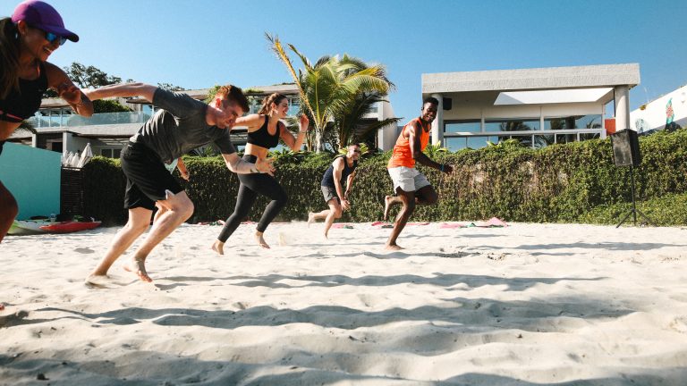 a group of people running on sand