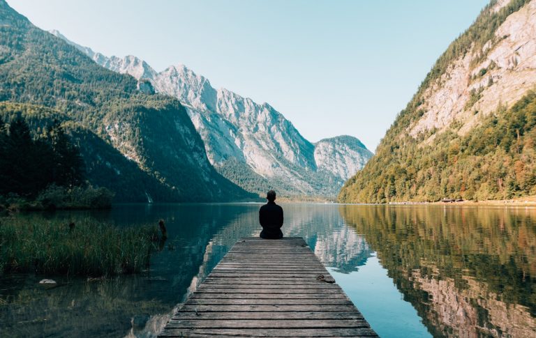 a person sitting on a dock overlooking a lake