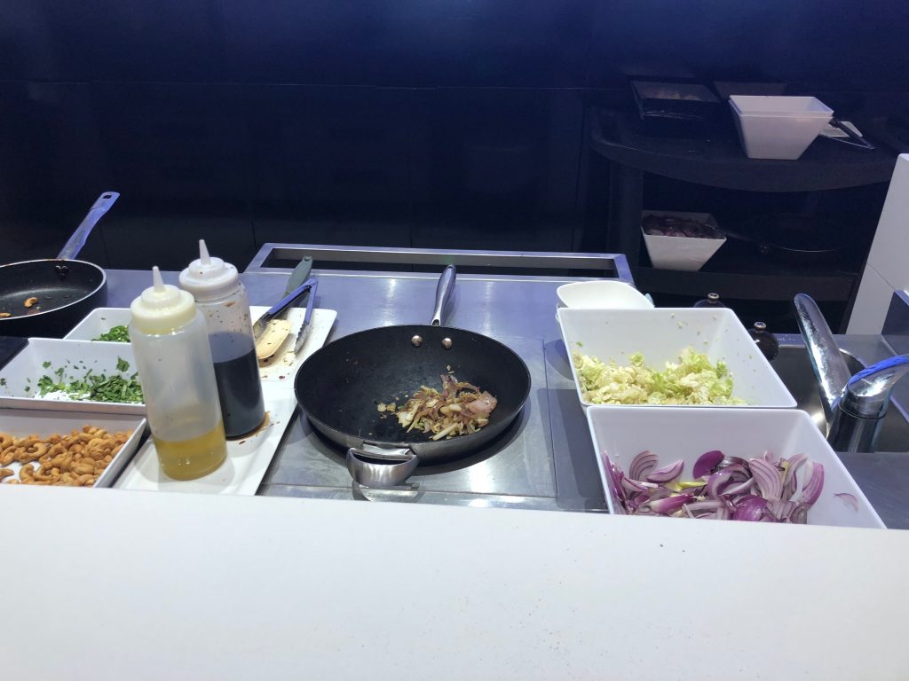 a pan with vegetables and sauces on a counter