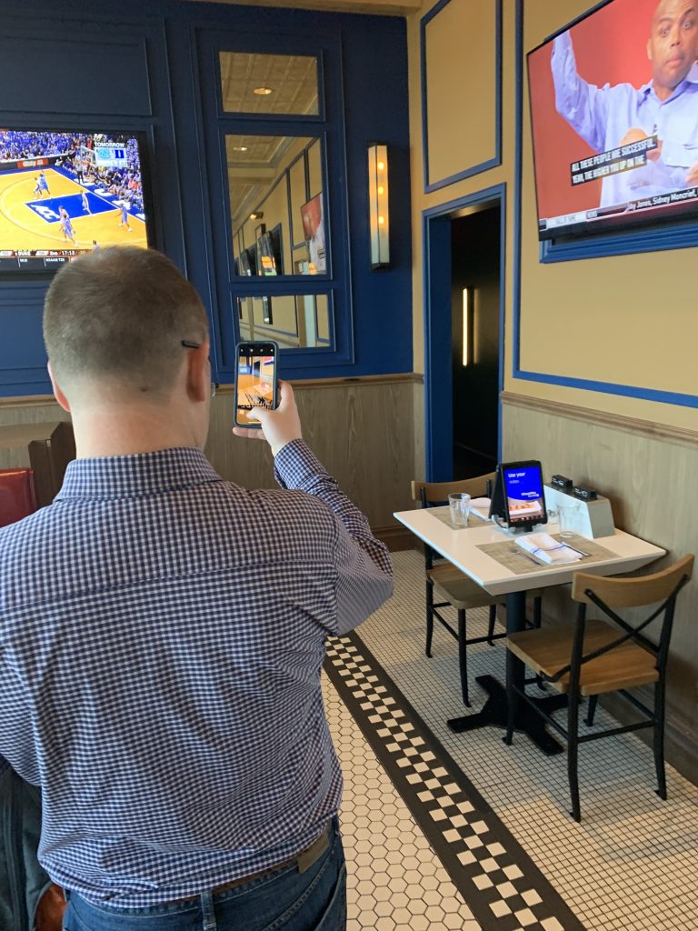 a man taking a picture of a basketball game