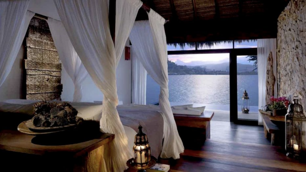 a room with a bed and a window overlooking a body of water