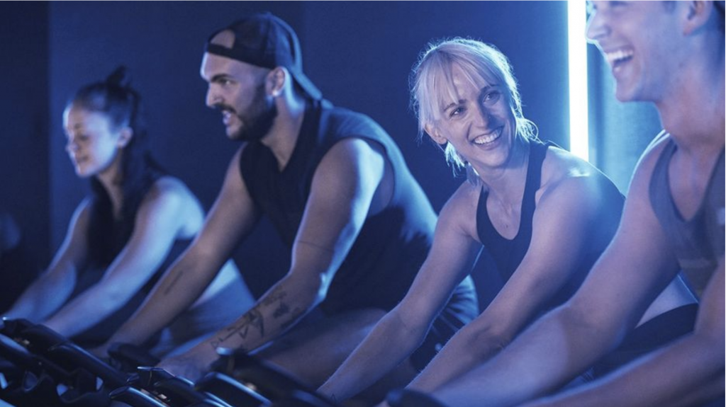 a group of people on exercise bikes