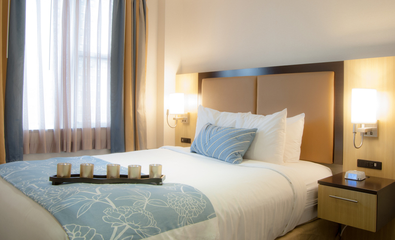 a bed with a blue and white blanket and pillows