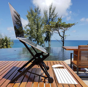 a laptop on a table by a pool