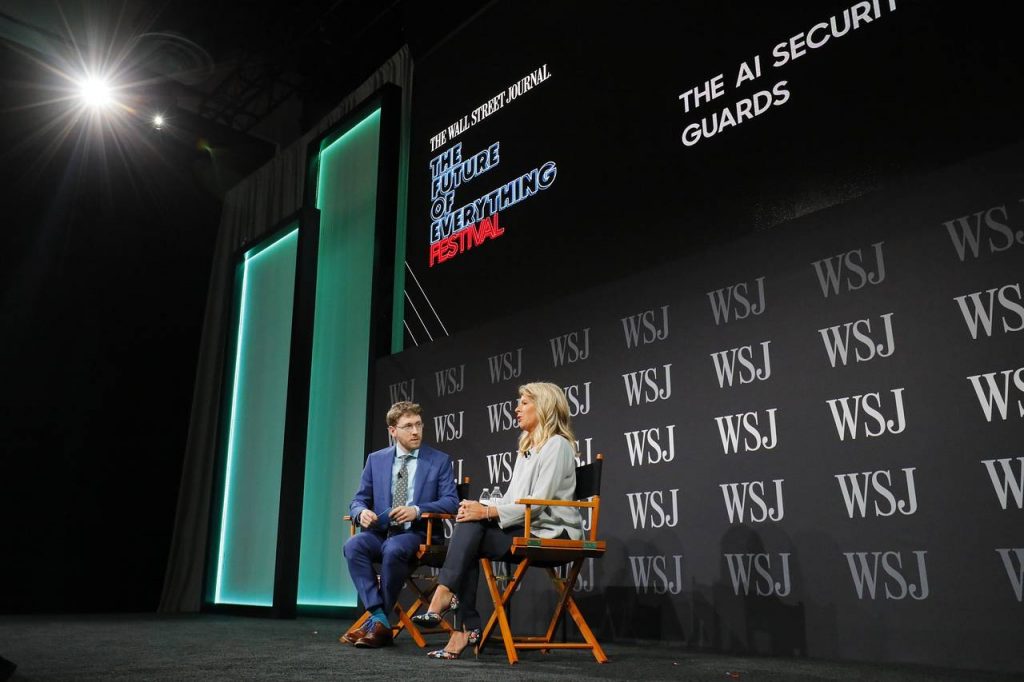 a man and woman sitting in chairs on a stage