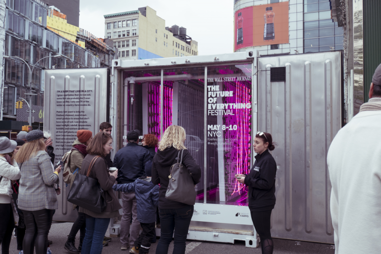 a group of people standing in front of a large container