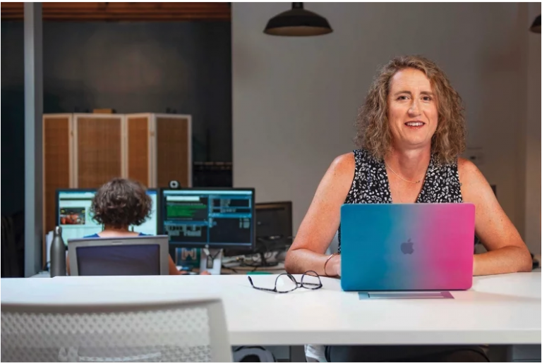 a woman sitting at a desk with a laptop