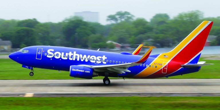 a blue and yellow airplane on a runway