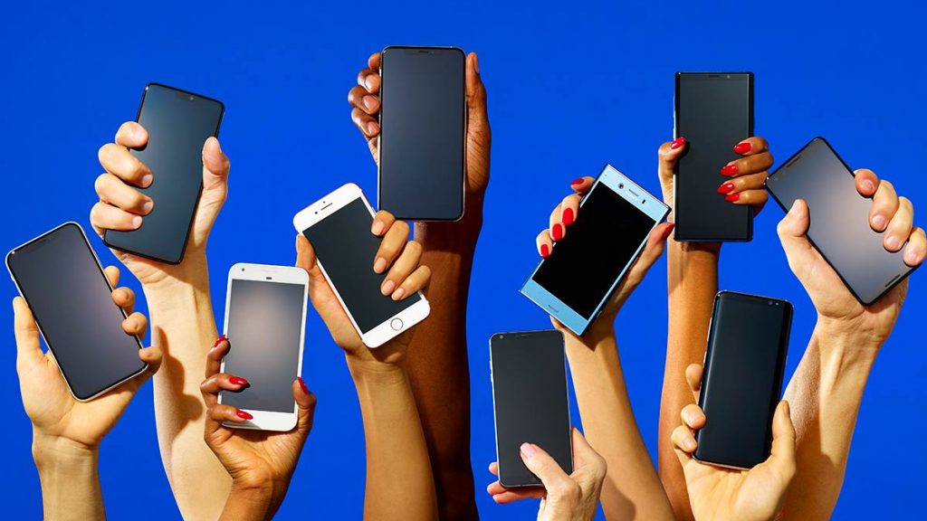 a group of hands holding cell phones