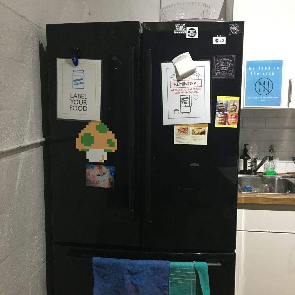 a black refrigerator with magnets and papers on it
