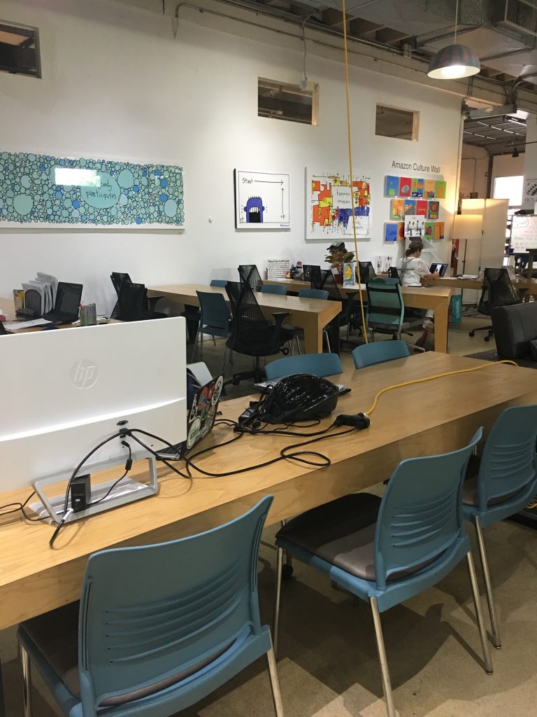 a room with a large table with chairs and computers