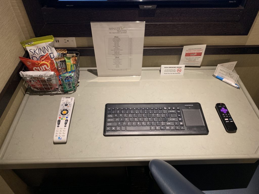 a desk with a keyboard and a basket of snacks