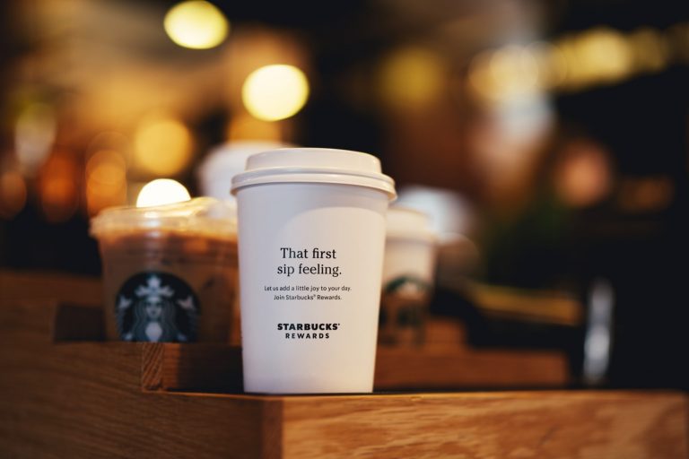 a white coffee cup on a wooden tray