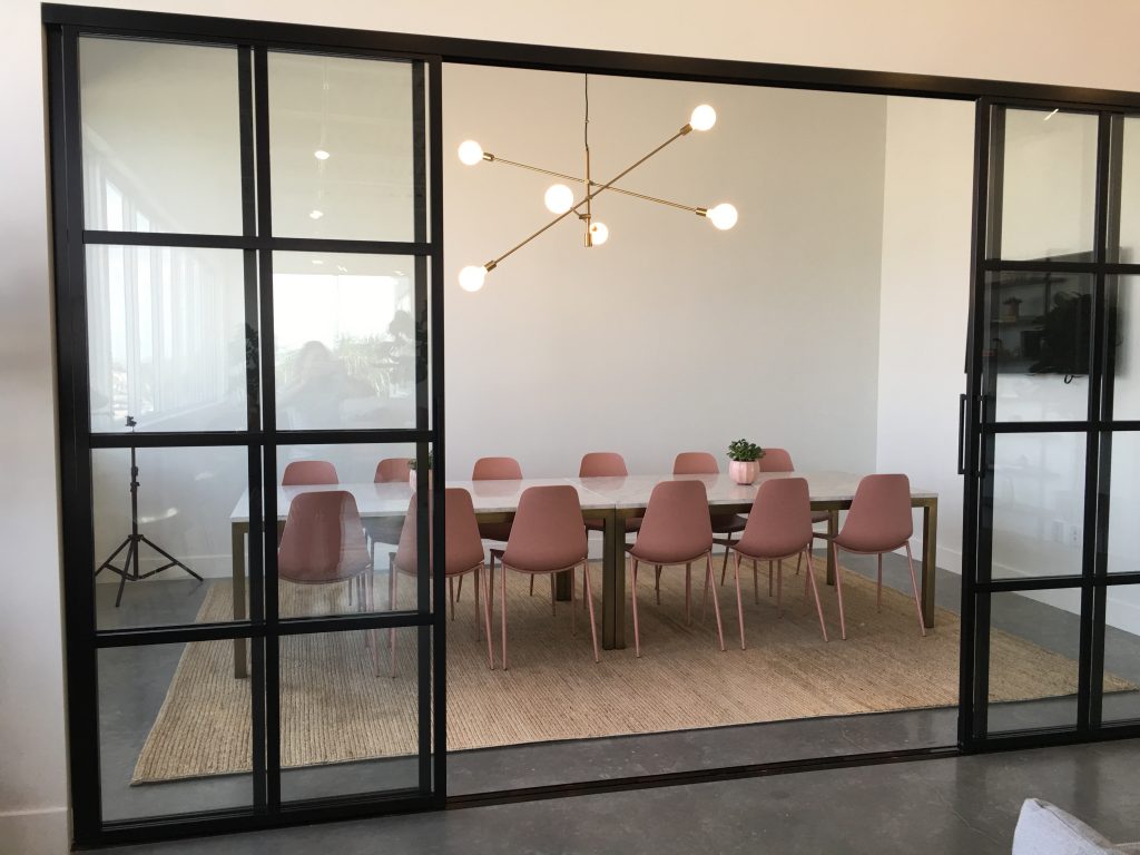 a dining table with pink chairs in a room