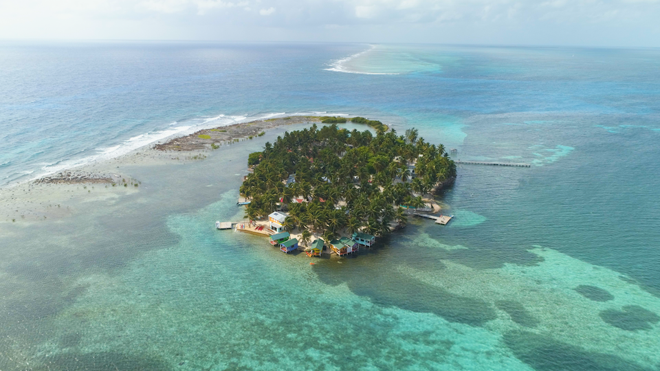 an island with houses and trees in the water