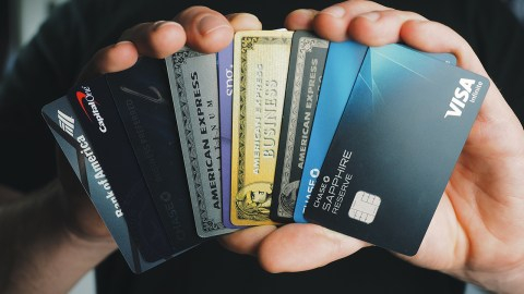 a hand holding several credit cards