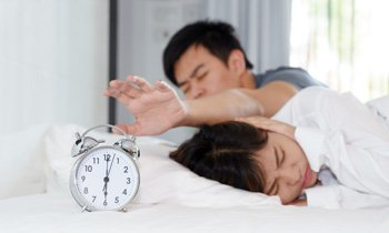 a man and woman lying down in bed