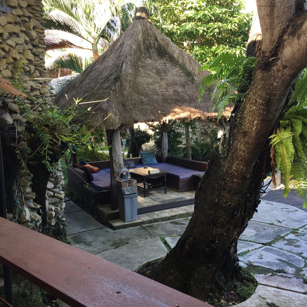 a patio with a thatched roof and a couch
