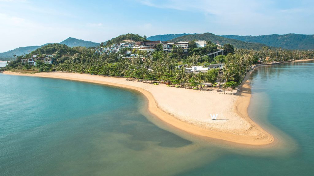 a beach with trees and buildings