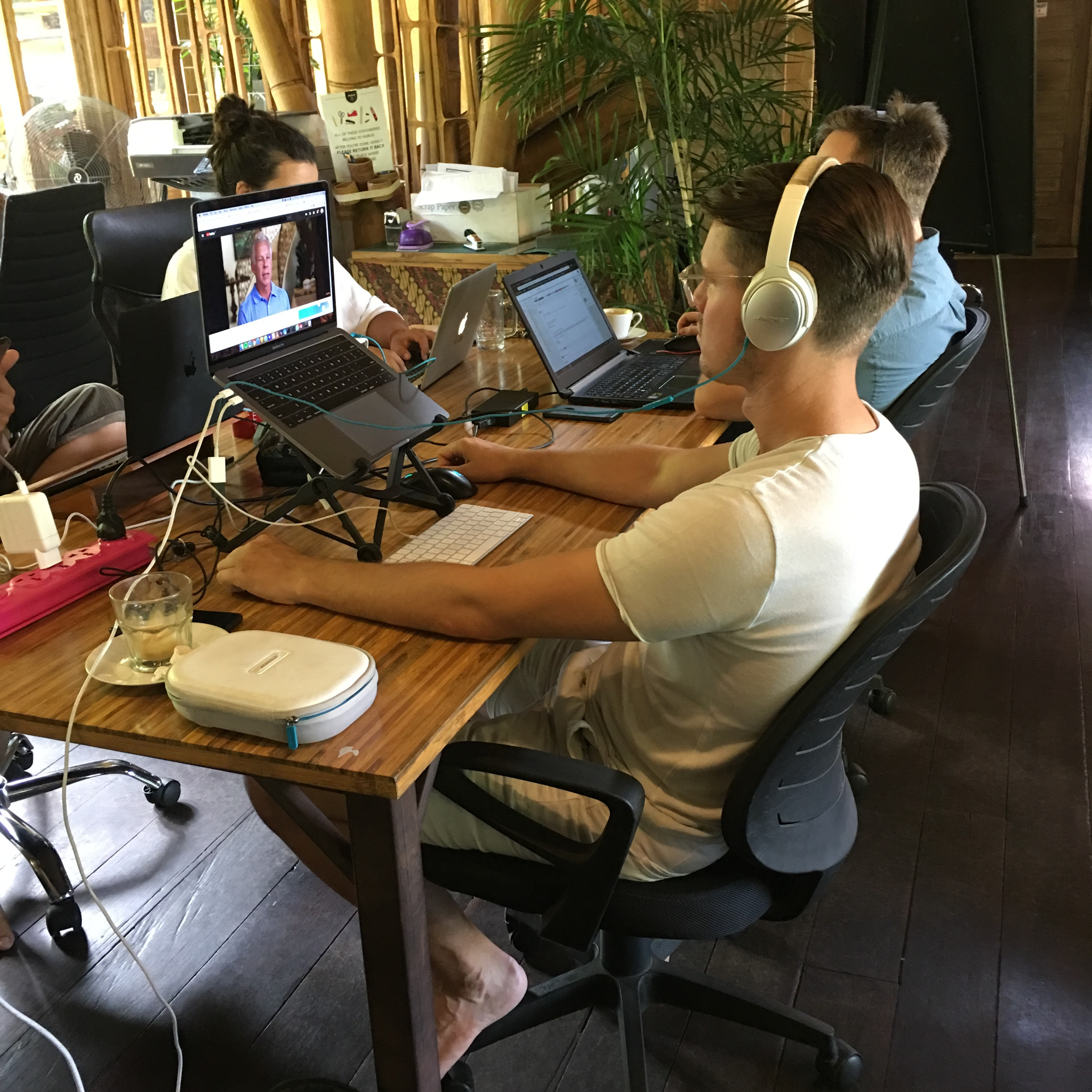 a group of people sitting at a table with laptops