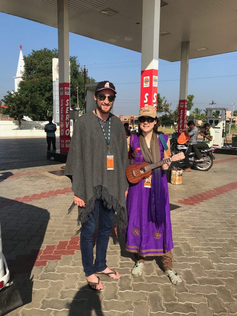 a man and woman standing outside with a guitar