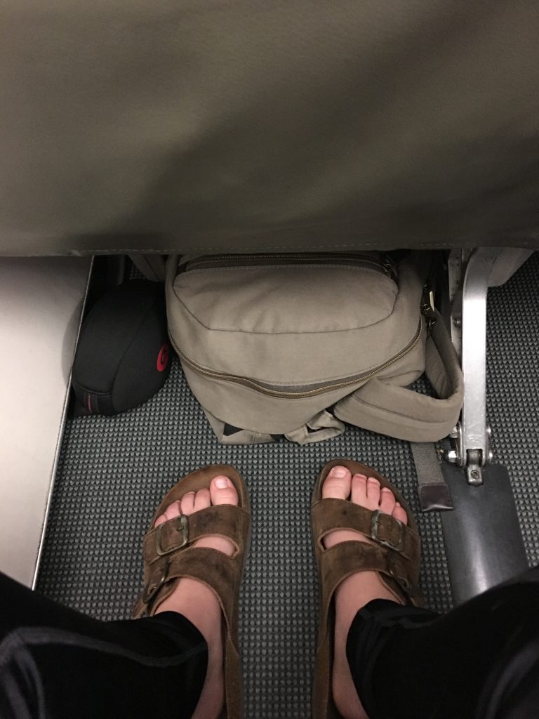a person's feet in sandals and a backpack