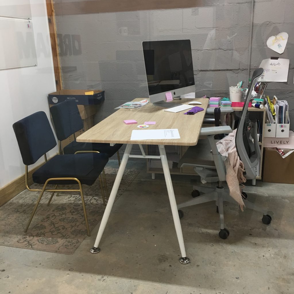 a desk with a computer and a chair