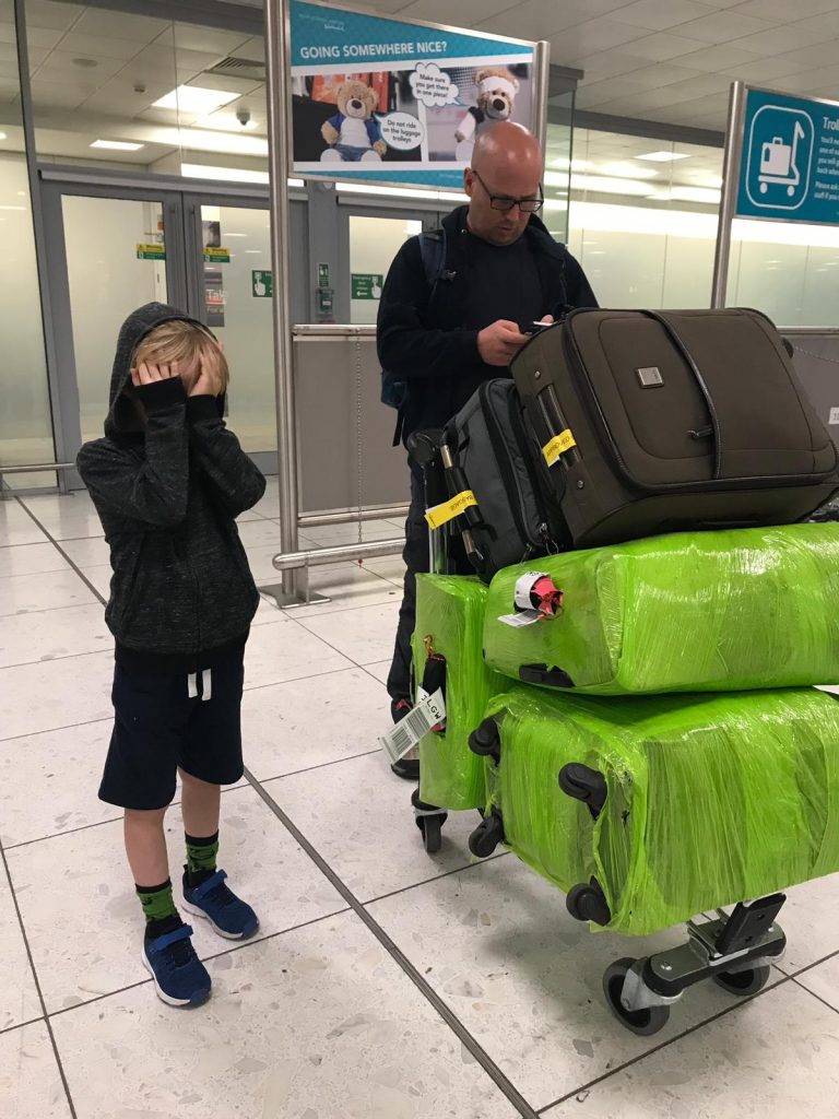 a man and child standing next to luggage