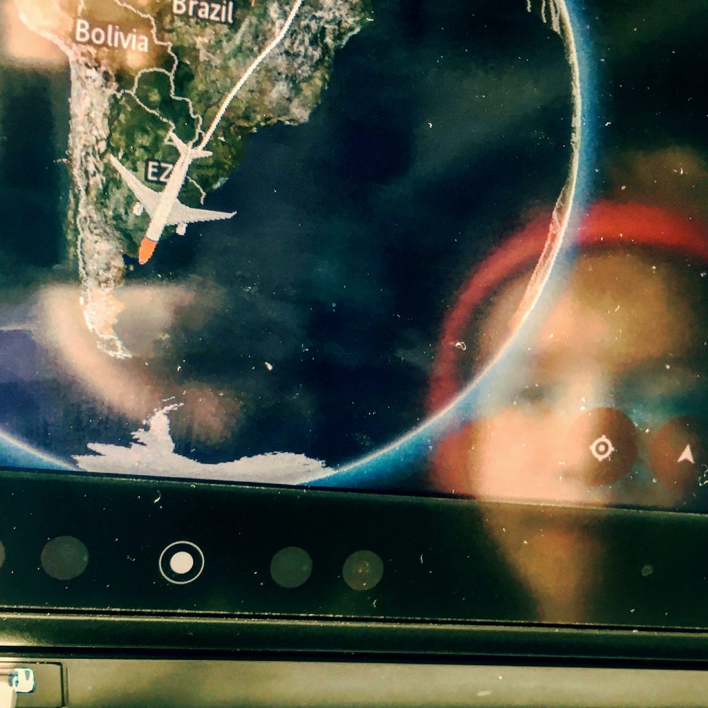 a screen with a picture of a plane flying over the earth