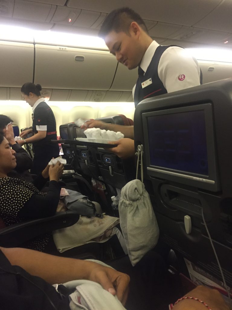 a man serving food on a plane