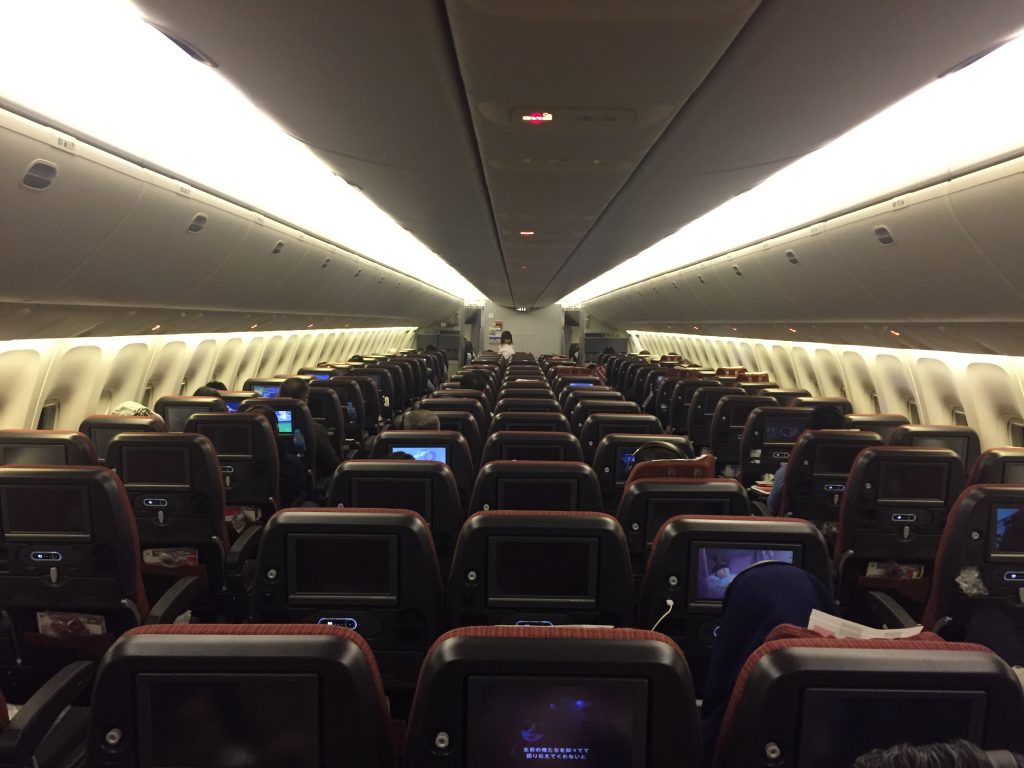 an airplane with rows of seats and monitors