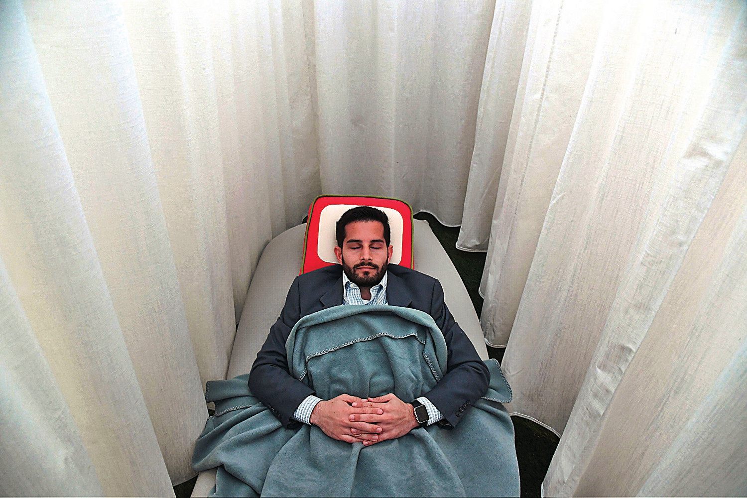 a man lying in a chair with a blanket