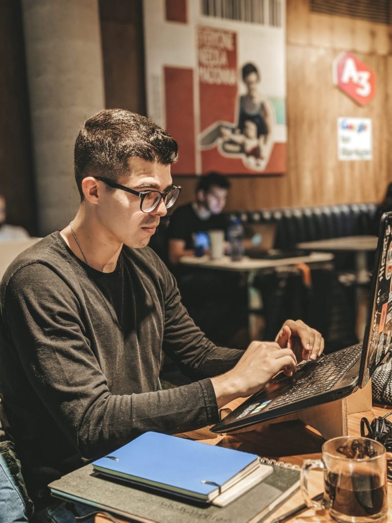 a man sitting at a table using a laptop