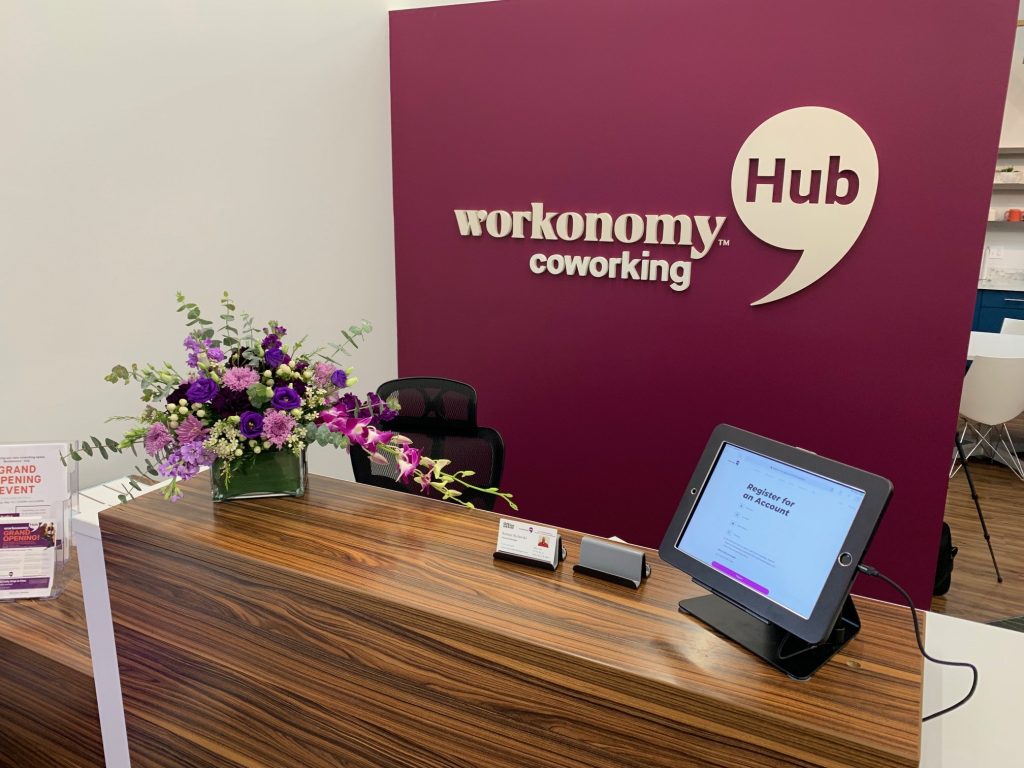 a desk with a tablet and flowers on it